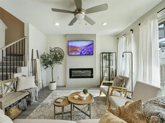 a living room with furniture a fireplace and a flat screen tv