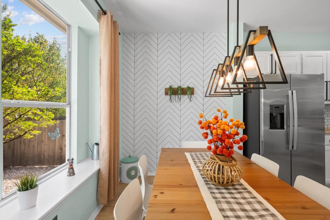12201 Barrel Bend Austin, TX 78748 - Photo 12 of 35 Dining room with healthy amount of natural light, a chandelier, and an accent wall