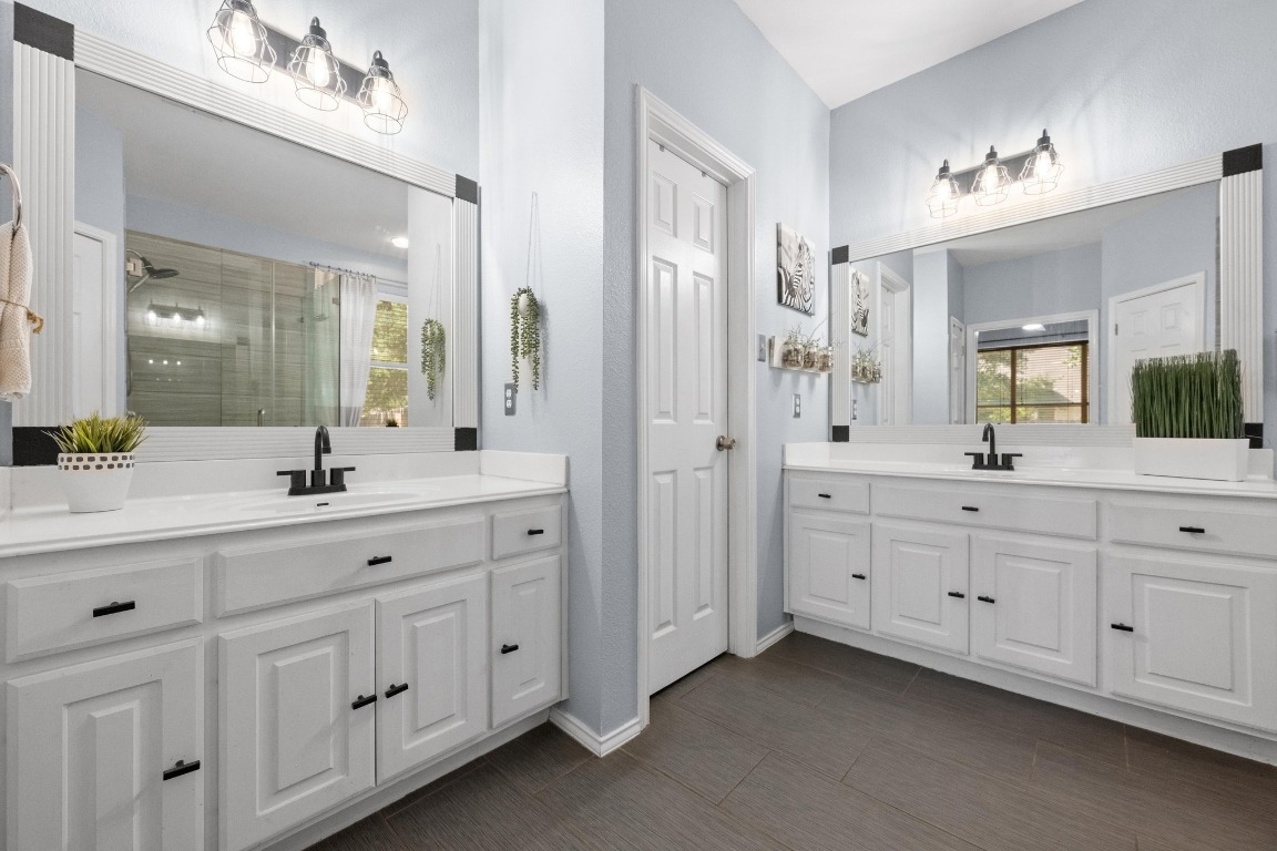12201 Barrel Bend Austin, TX 78748 - Photo 19 of 35 Full bath featuring a shower stall and two vanities