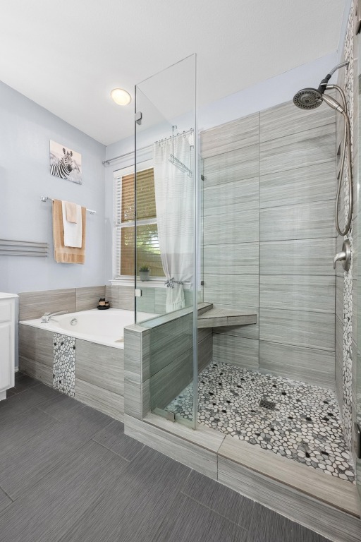 12201 Barrel Bend Austin, TX 78748 - Photo 21 of 35 Bathroom featuring a garden tub, a stall shower, and tile patterned flooring