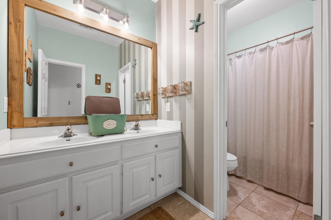 12201 Barrel Bend Austin, TX 78748 - Photo 27 of 35 Bathroom featuring light tile patterned flooring, double vanity, and curtained shower