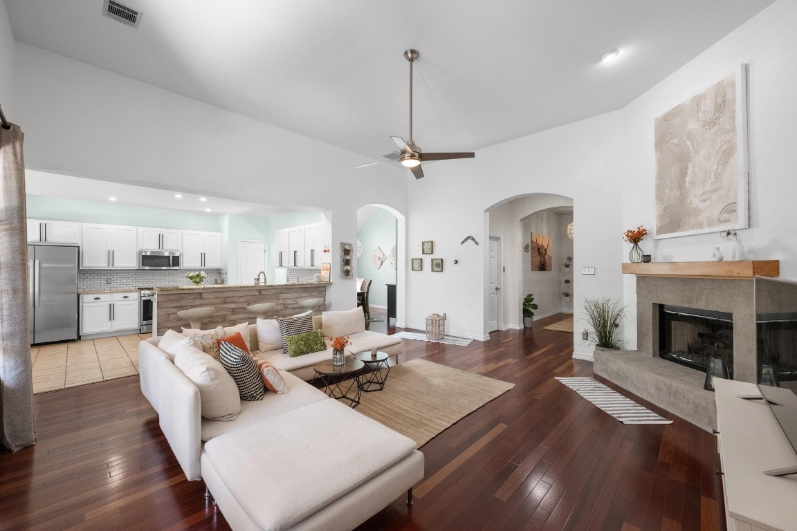 12201 Barrel Bend Austin, TX 78748 - Photo 7 of 35 Living area with a ceiling fan, a fireplace, recessed lighting, dark wood-style flooring, and arched walkways