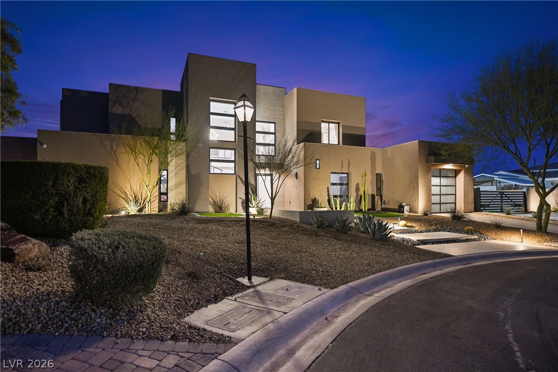3740 Caesars Circle Las Vegas, NV 89120 - Photo 4 of 89 This modern home glows under the twilight sky, highlighting its unique architectural design.