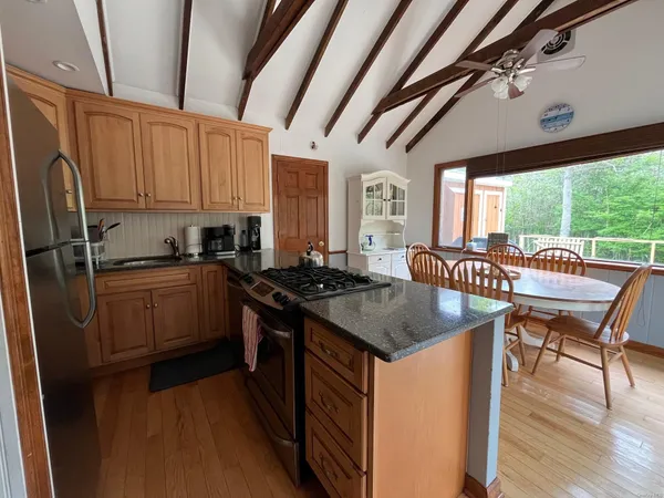 a kitchen with stainless steel appliances granite countertop sink stove top oven and cabinets
