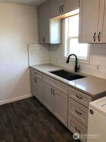 a kitchen with cabinets appliances a sink and a window