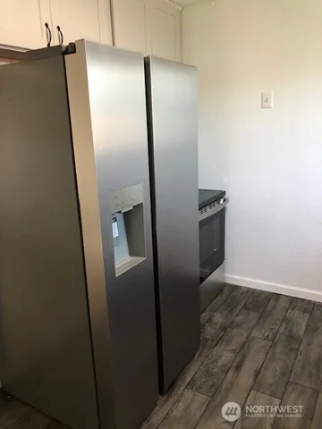a view of a refrigerator in kitchen and wooden floor