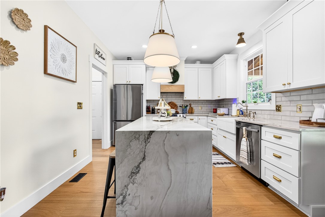 5016 Copeland Road Belton, SC 29627 - Photo 10 of 45 White cabinetry, sleek stainless appliances, and warm wood flooring define this contemporary kitchen.