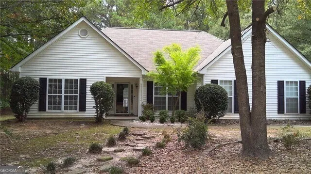 a view of a house with backyard and sitting area