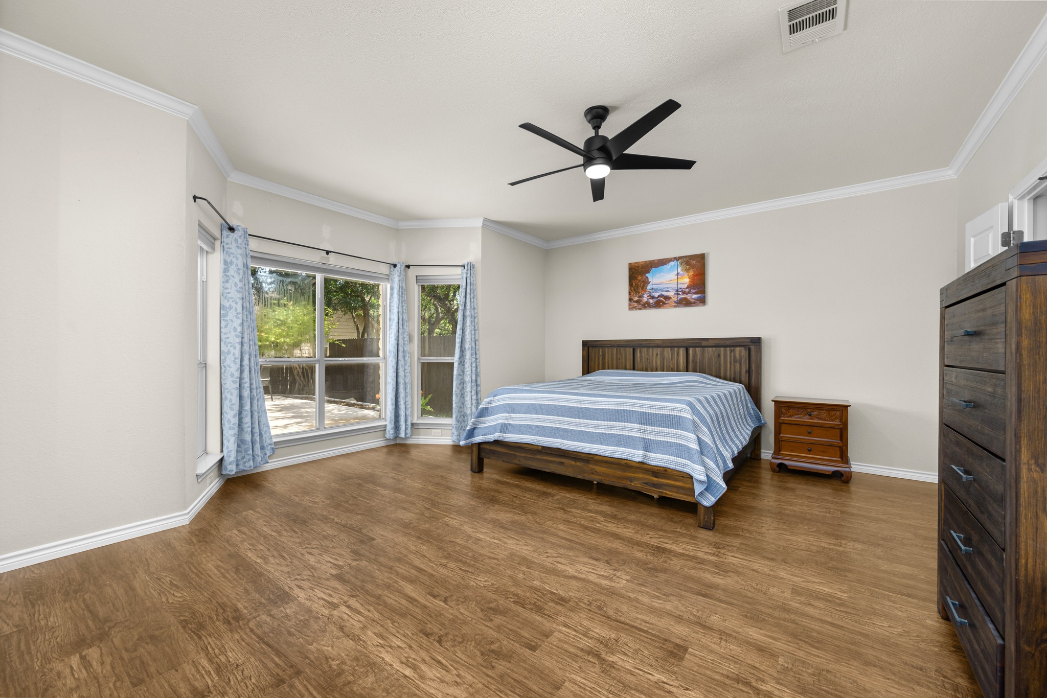 108 Thornwood Road Georgetown, TX 78628 - Photo 19 of 40 Natural light floods this inviting bedroom with wide plank wood-look flooring and a contemporary ceiling fan.
