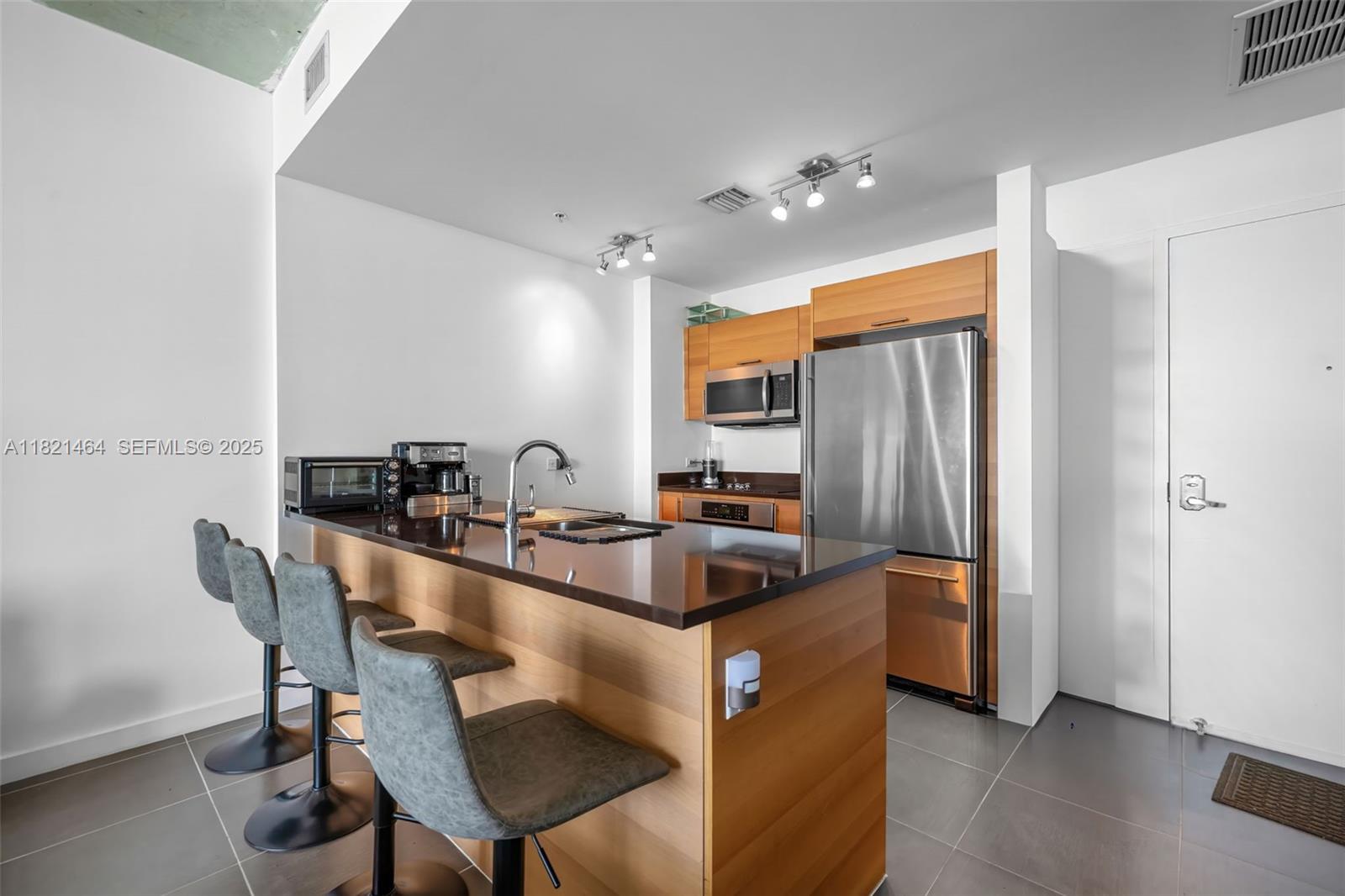 Midtown Miami Miami, FL 33137 - Photo 5 of 17 a kitchen with stainless steel appliances a dining table chairs and refrigerator