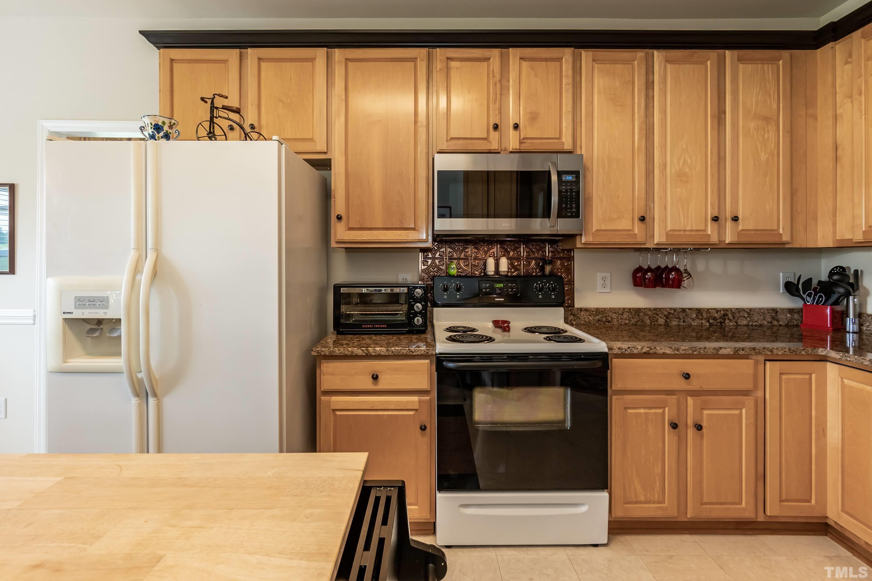 342 Seastone Street Raleigh, NC 27603 - Photo 13 of 50 a kitchen with stainless steel appliances granite countertop a refrigerator a stove a sink and a microwave