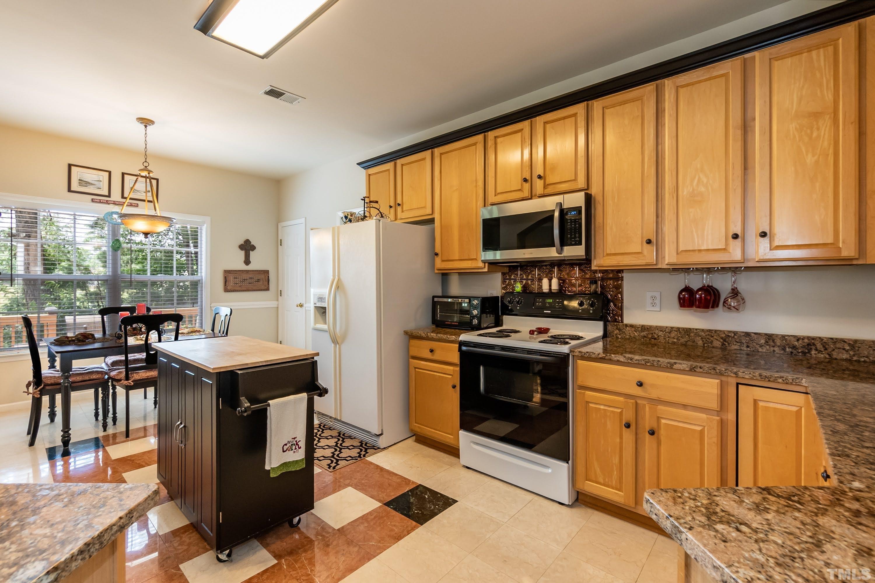 342 Seastone Street Raleigh, NC 27603 - Photo 14 of 50 a kitchen with stainless steel appliances granite countertop a stove top oven refrigerator a sink dishwasher and a stove