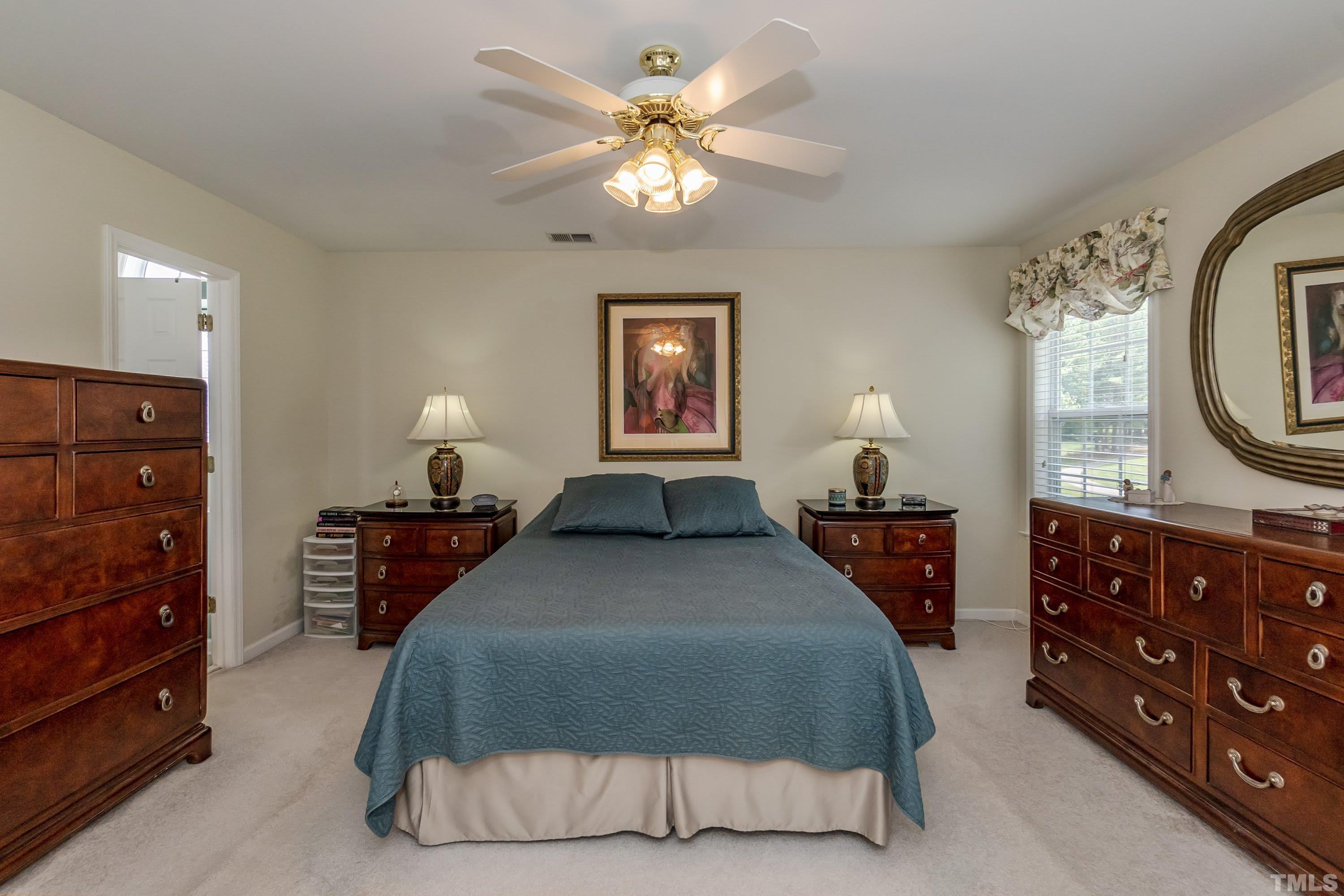 342 Seastone Street Raleigh, NC 27603 - Photo 24 of 50 a bedroom with a bed a chandelier and dresser