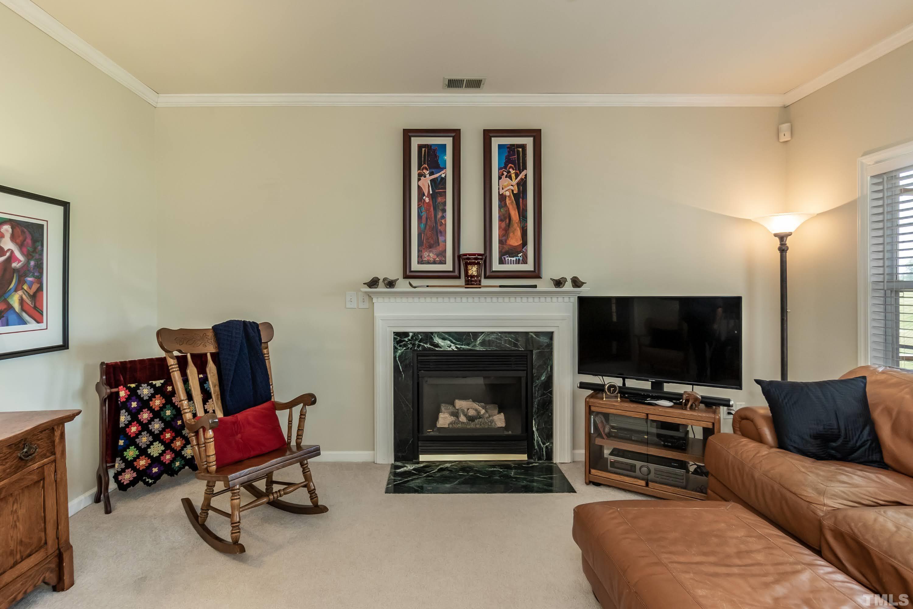 342 Seastone Street Raleigh, NC 27603 - Photo 7 of 50 a living room with furniture a flat screen tv and a fireplace
