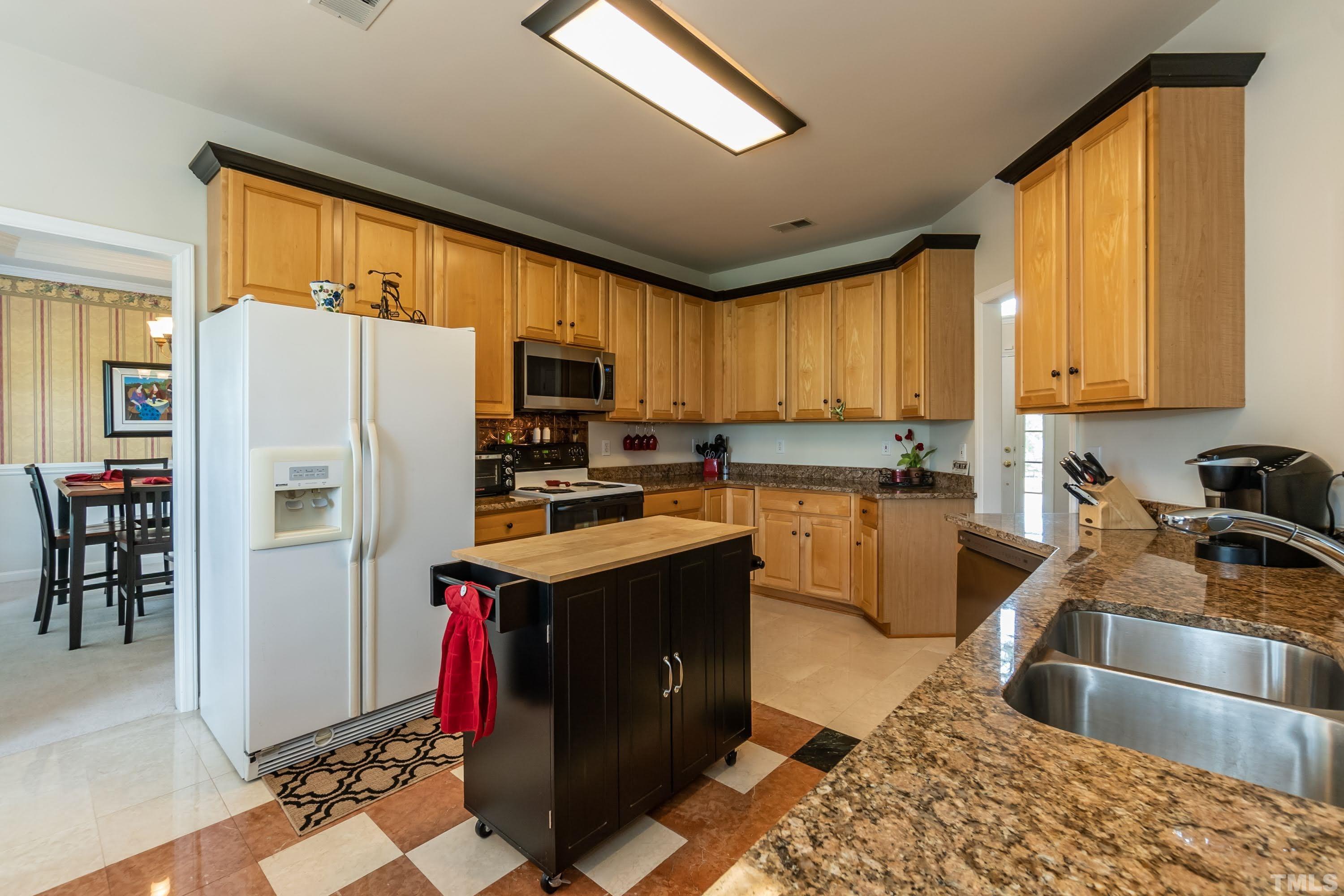 342 Seastone Street Raleigh, NC 27603 - Photo 10 of 50 a kitchen with granite countertop a refrigerator stove top oven and sink