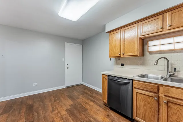 a view of a kitchen sink a stove and cabinets
