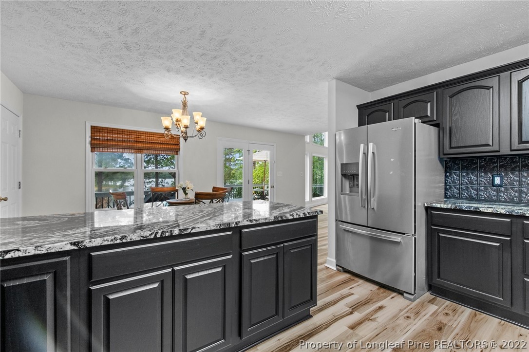 30420 East Lake Road Wagram, NC 28396 - Photo 29 of 35 a kitchen with granite countertop a refrigerator and a sink