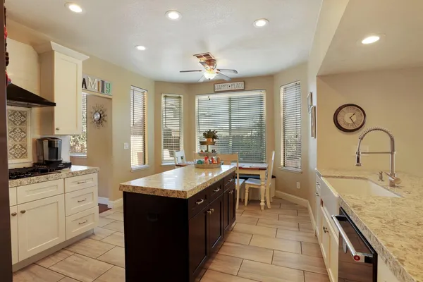 a kitchen with granite countertop a stove and a white cabinets