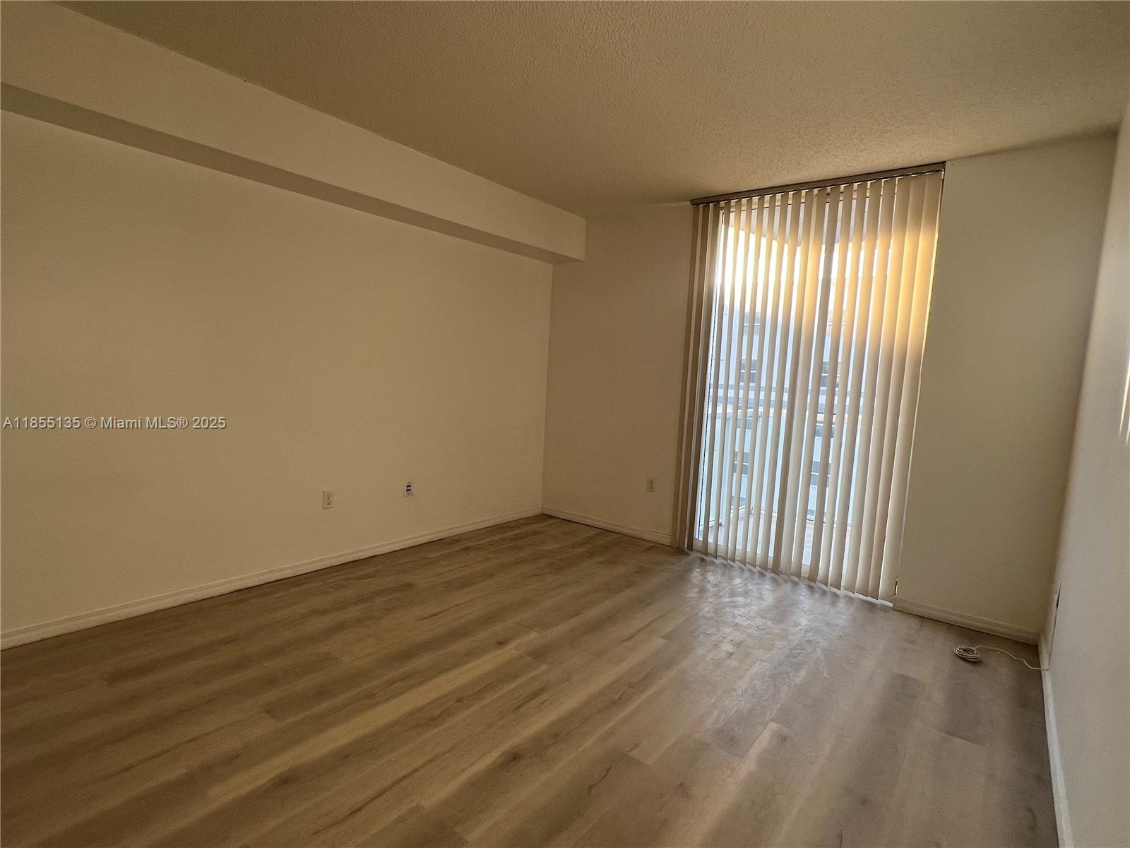 5077 Northwest 7th Street, Unit PH4 Miami, FL 33126 - Photo 23 of 25 an empty room with wooden floor and windows