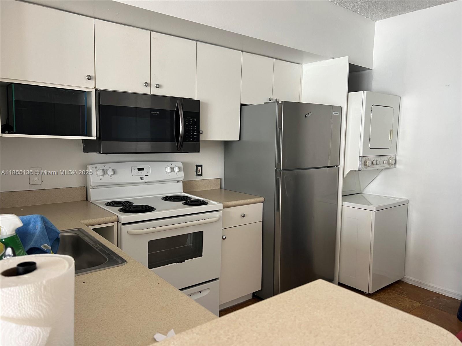5077 Northwest 7th Street, Unit PH4 Miami, FL 33126 - Photo 6 of 25 a kitchen with a refrigerator stove and microwave