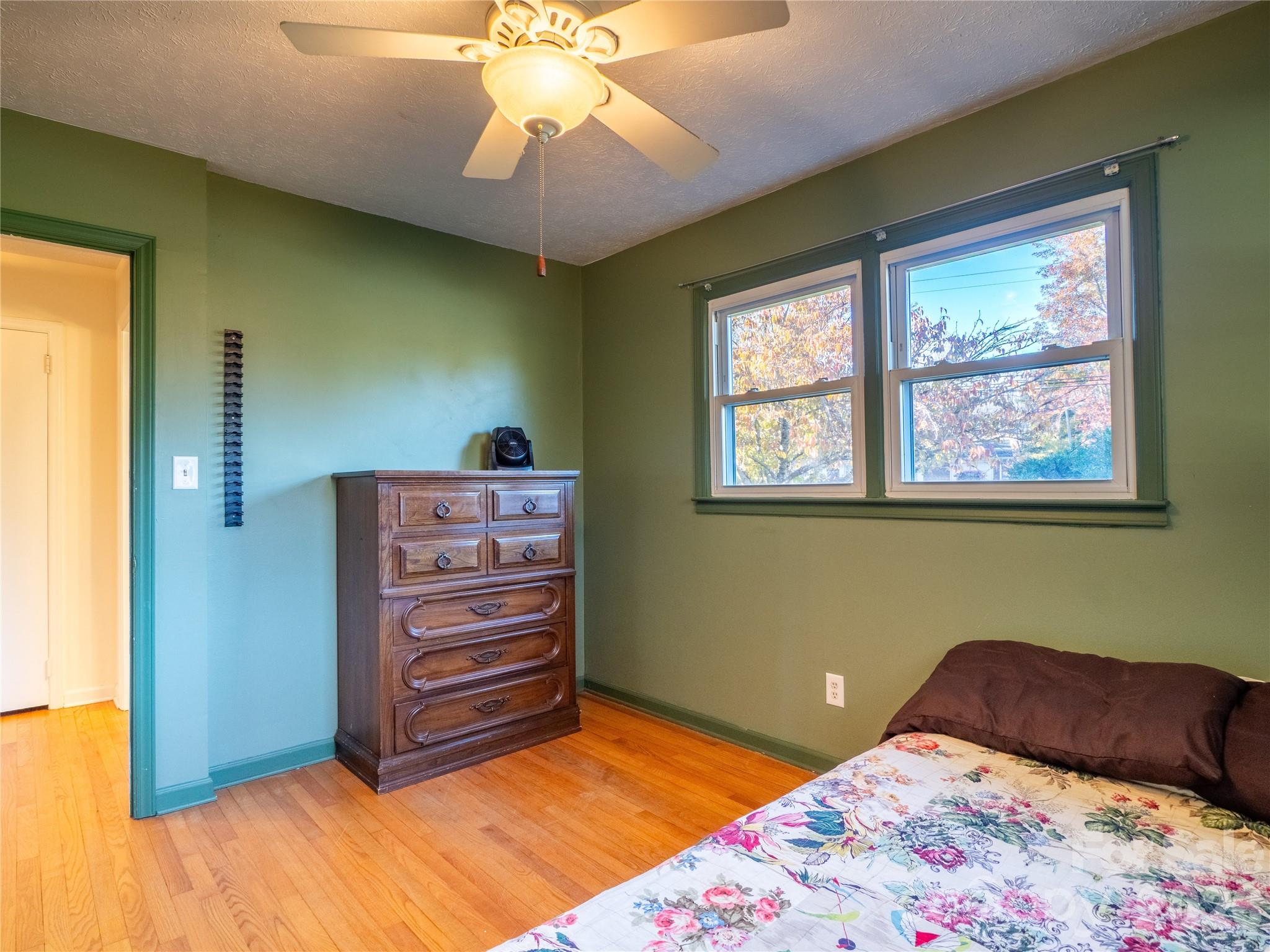 203 Oak Grove Road East Flat Rock, NC 28726 - Photo 15 of 24 a bedroom with a bed and a chandelier