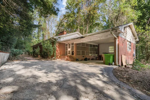 a view of a house with a yard and large tree