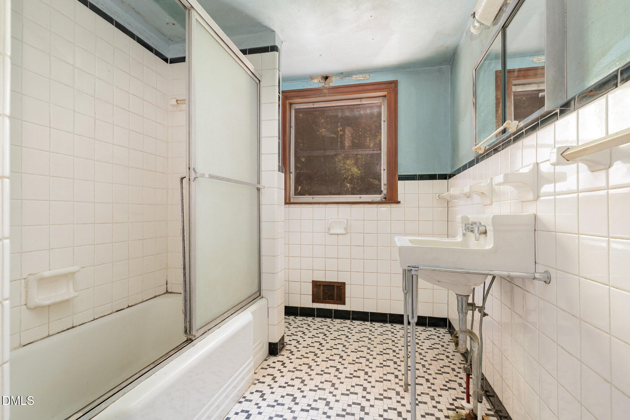 1312 Onslow Road Raleigh, NC 27606 - Photo 14 of 26 a bathroom with a sink a mirror and shower