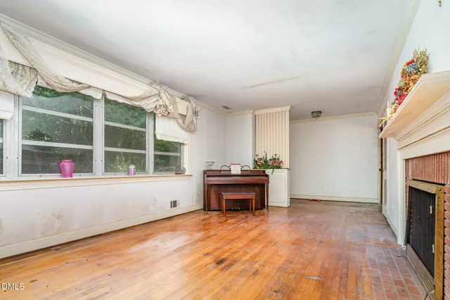 an empty room with a fireplace and window
