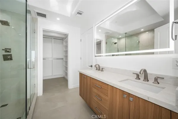 a spacious bathroom with a shower sink and mirror
