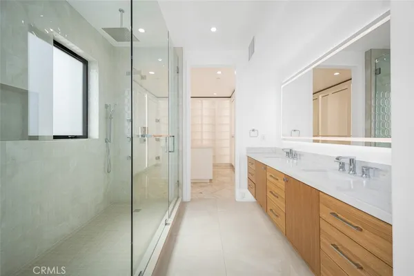 a spacious bathroom with a shower sink and mirror