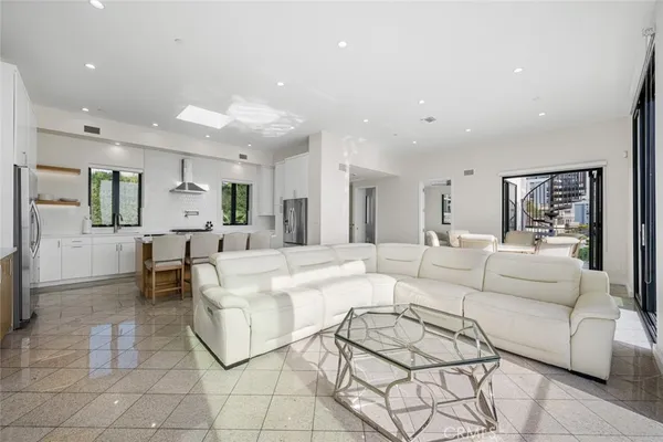 a living room with furniture and a dining table with kitchen view