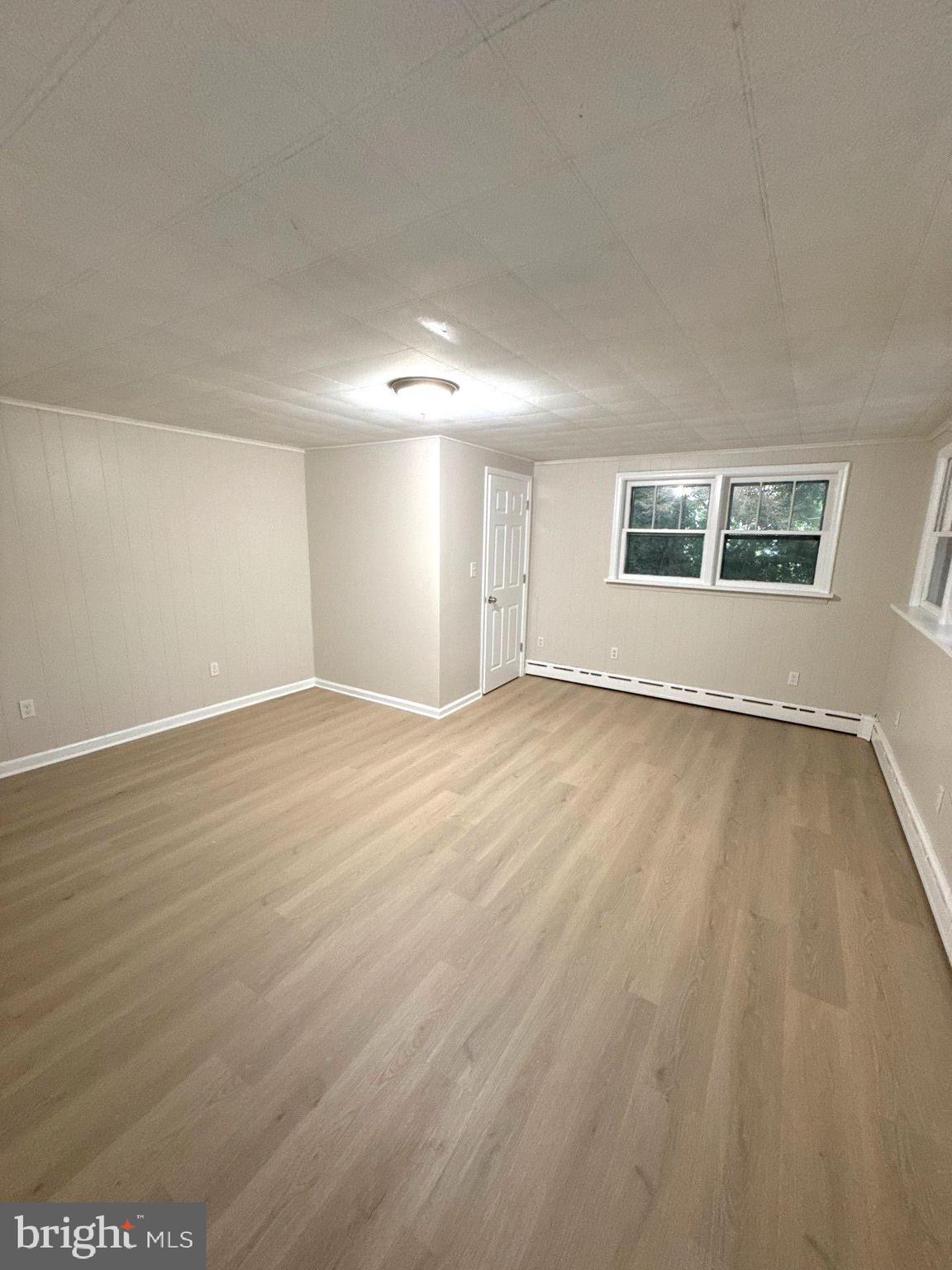 105 Atlantic Street, Unit F1 Bridgeton, NJ 08302 - Photo 2 of 9 an empty room with wooden floor and windows