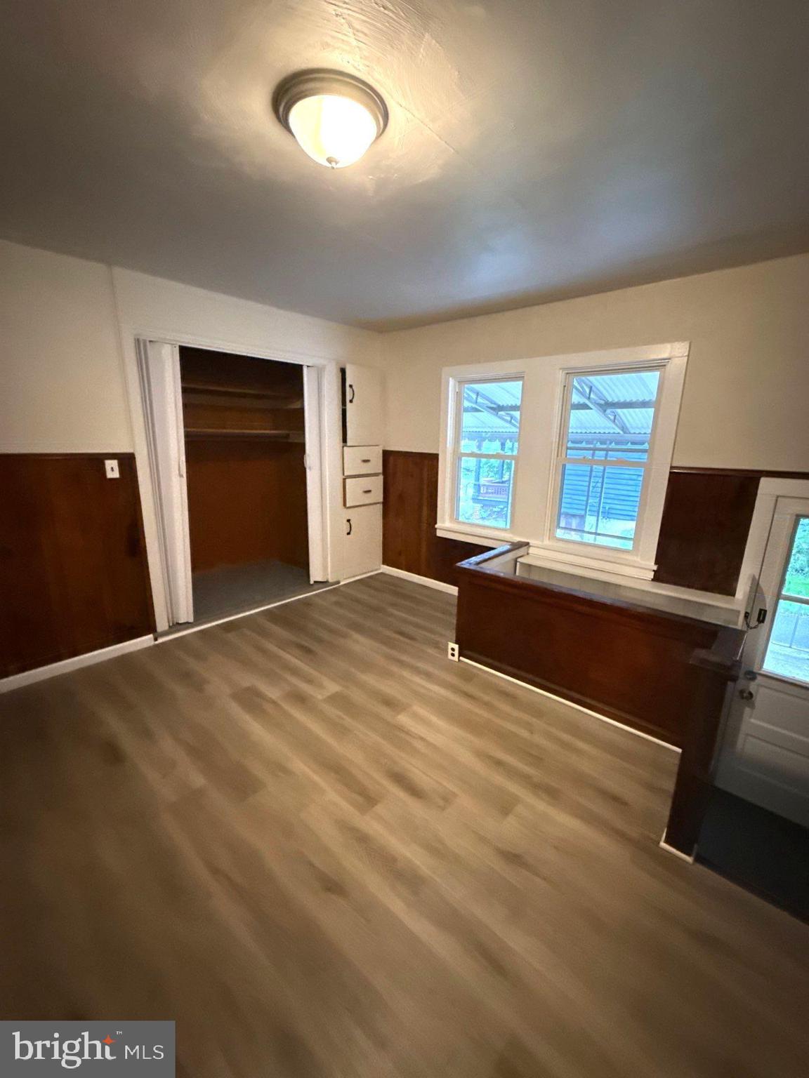 105 Atlantic Street, Unit F1 Bridgeton, NJ 08302 - Photo 6 of 9 a bedroom with a bed and a black dresser next to a window