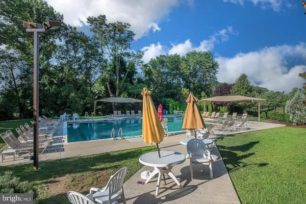 a view of backyard with swimming pool and seating