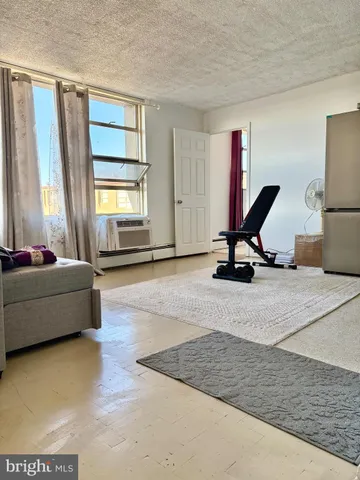 a living room with a couch a window and gym cycle