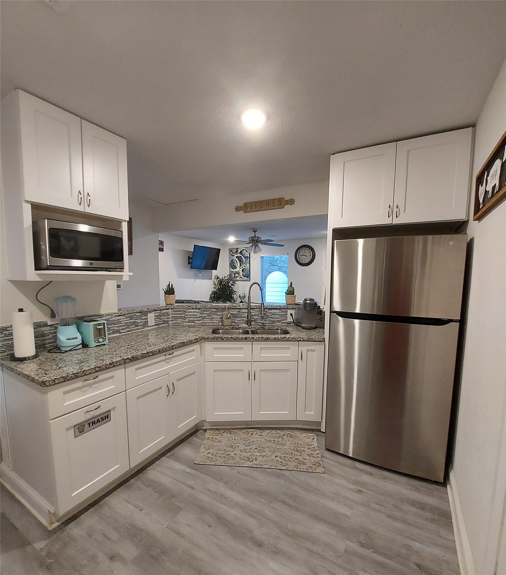 20202 McShepherd Road Georgetown, TX 78626 - Photo 16 of 40 Kitchen with stainless steel appliances, light stone counters, white cabinets, and ceiling fan