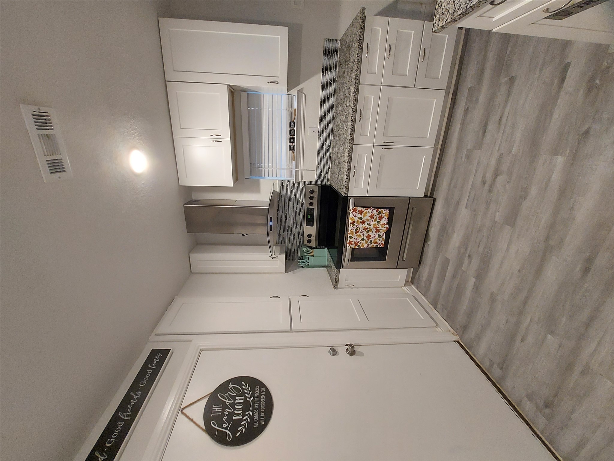 20202 McShepherd Road Georgetown, TX 78626 - Photo 17 of 40 Kitchen featuring white cabinets, stainless steel electric range oven, light wood-style flooring, and dark stone countertops