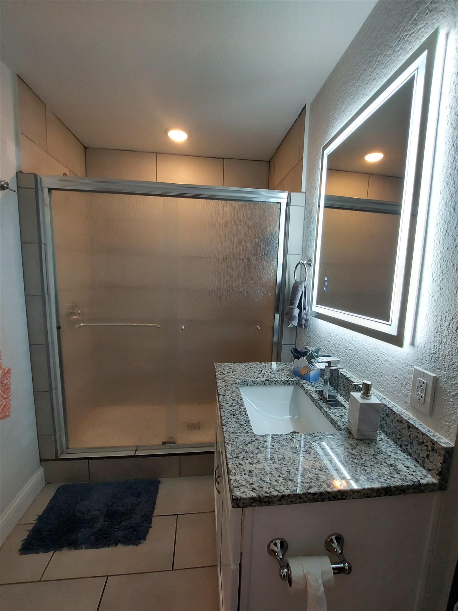 20202 McShepherd Road Georgetown, TX 78626 - Photo 29 of 40 Bathroom featuring a textured wall, vanity, a stall shower, light tile patterned flooring, and recessed lighting