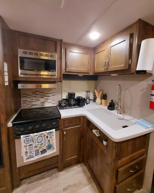 20202 McShepherd Road Georgetown, TX 78626 - Photo 32 of 40 Kitchen featuring light countertops, stainless steel microwave, and light tile patterned floors