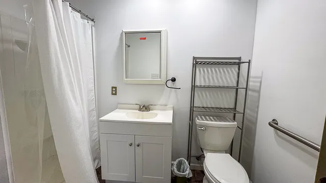 a bathroom with a sink a toilet and shower