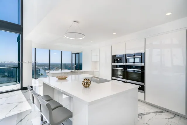 a kitchen with a sink a stove and chairs