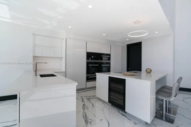 a kitchen with a refrigerator and chairs