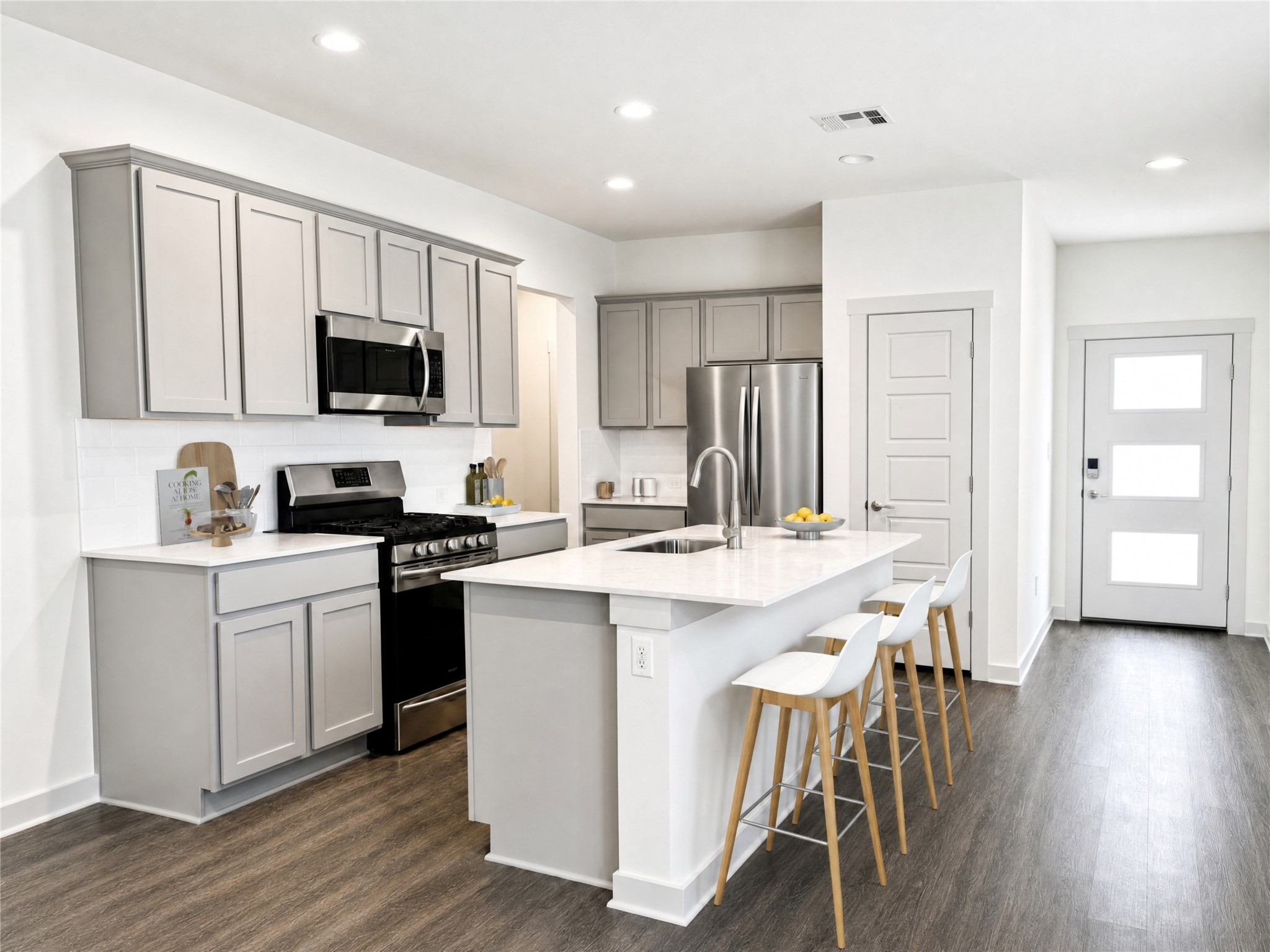 5128 Vanner Path Georgetown, TX 78626 - Photo 7 of 20 Picture digitally staged. Modern kitchen featuring light gray cabinetry, white countertops, and stainless steel appliances