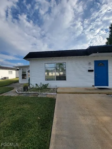 a backyard of a house with table and chairs