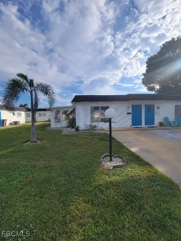 a backyard of a house with table and chairs