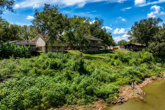 a front view of a house with a yard and lake view
