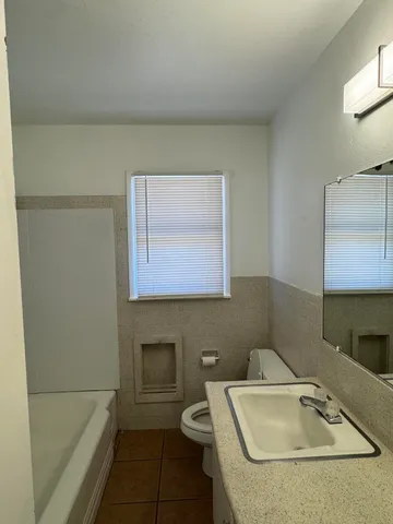 a bathroom with a sink toilet and mirror