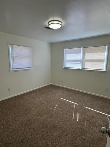 an empty room with windows and closet
