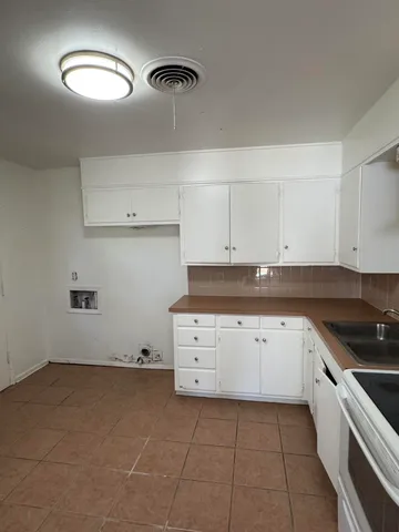 a kitchen with cabinets appliances and a sink