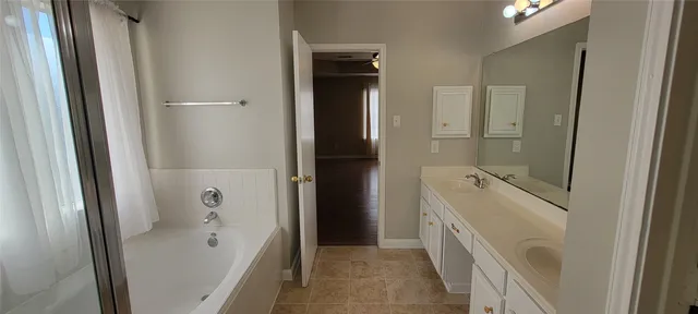 a bathroom with a tub sink and mirror